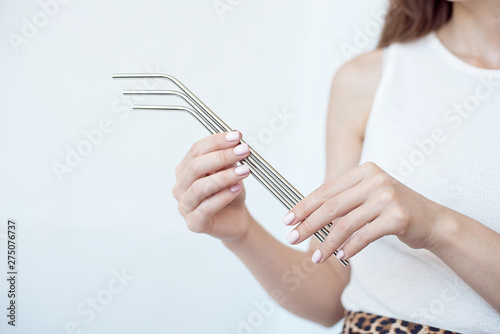 Girl is holding stainless steel straws to reduce the amount of plastic waste in the environmen