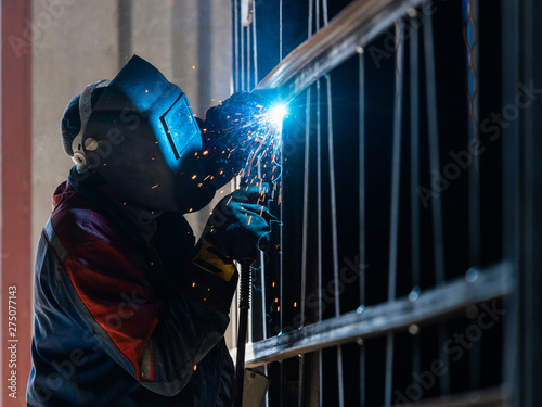 Obraz na płótnie Industrial Worker labourer at the factory arc welding steel structure w salonie
