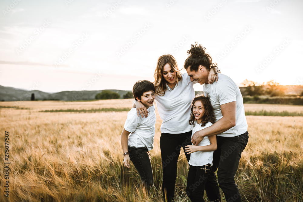 Portrait of a happy young family smiling in the countryside. Concept of family fun in nature.