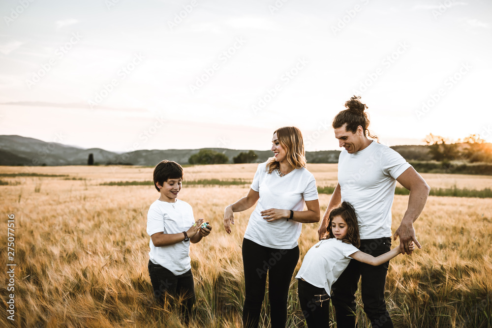 Portrait of a happy young family smiling in the countryside. Concept of family fun in nature.