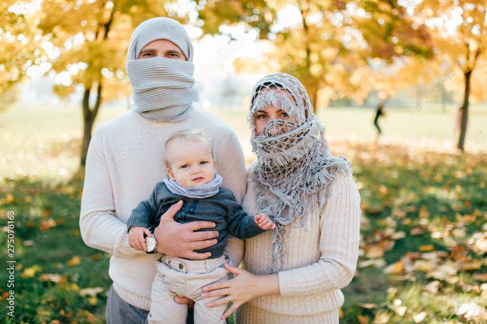 Strange family dressed like arabian people with their baby in hands. Arabian people wrapped in yashmak Strange family dressed like arabian people with their baby in hands. Arabian people wrapped in yashmak