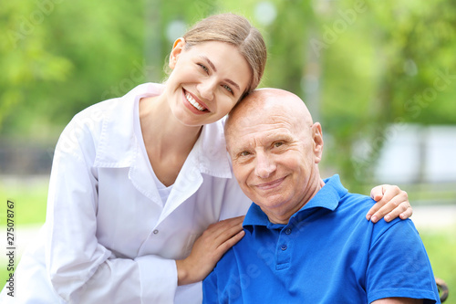 Elderly man with caregiver ...