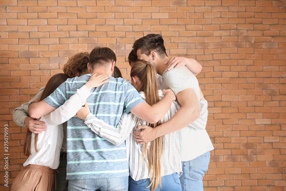 Young people hugging together at group therapy session