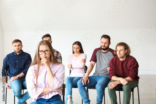 Sad young woman at group therapy session