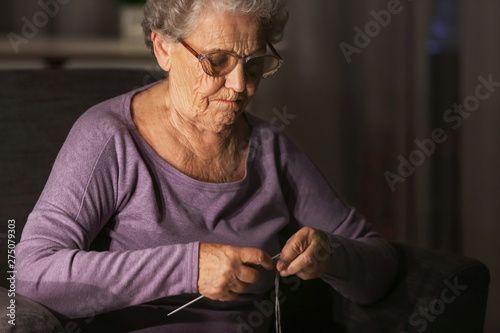 Senior woman knitting at ho...