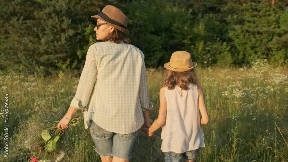 Mother and daughter walking holding hands, back view Mother and daughter walking holding hands, back view