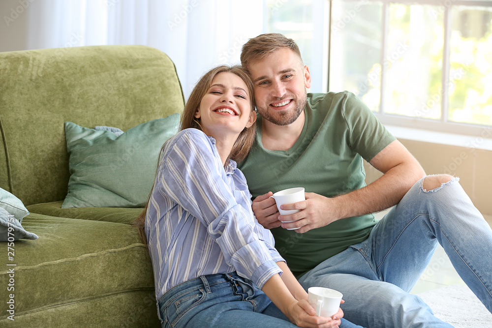 Portrait of happy young couple drinking coffee at home