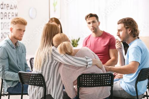 People calming woman at gro...