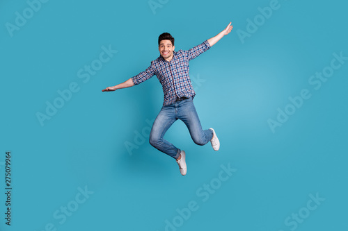 Full body length size photo of crazy humorous handsome carefree careless dreamy optimistic generation y millennial he him guy stretching arms hands to sides isolated pastel background © deagreez