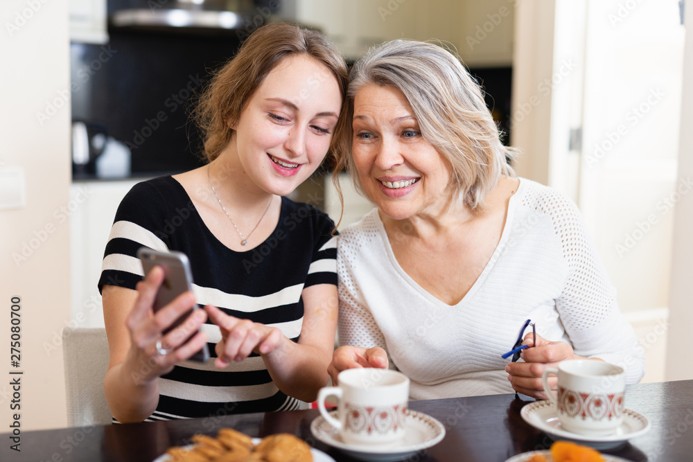 Mother with daughter using smartphone