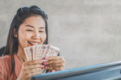happy Asian woman hand holding banknotes  make money online concept 
