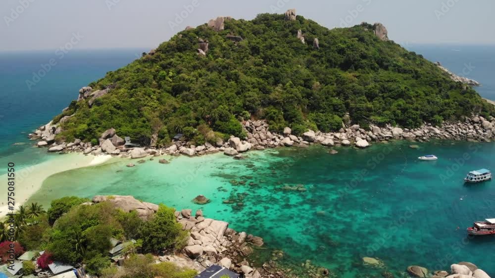 Boats near small islands. Motor dive boats floating on calm blue sea near unique small islets connected with white beaches and pier on sunny day in Thailand. Unique Nang yuan koh tao