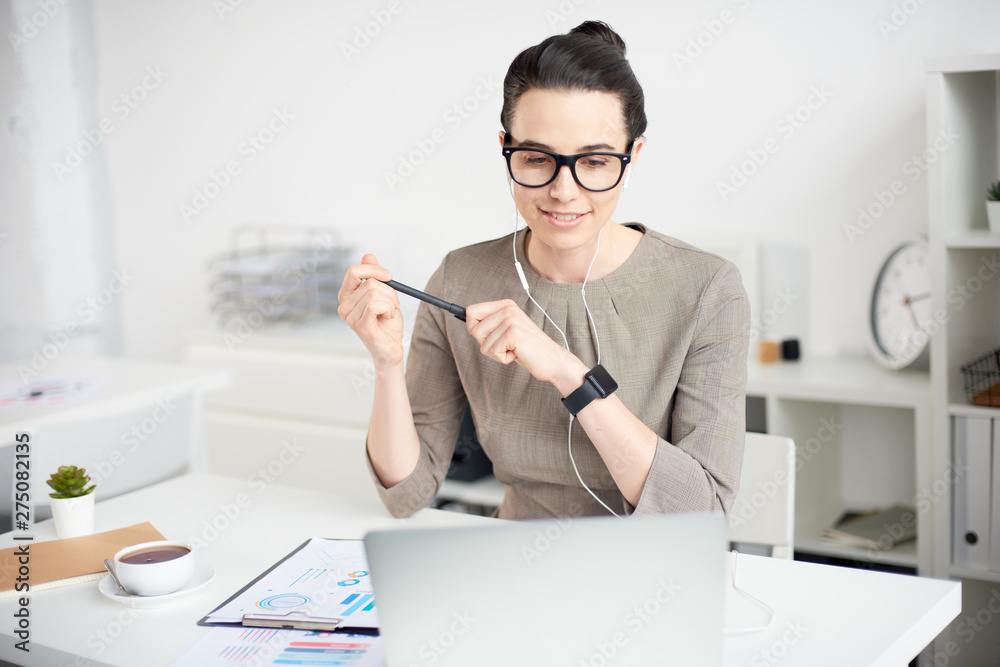 Mid age businesswoman working with documents on a laptop in the office Mid age businesswoman working with documents on a laptop in the office