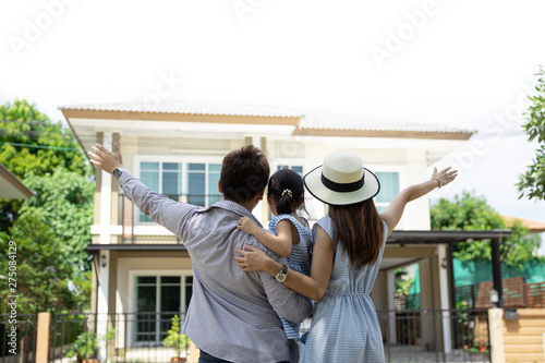 Happy Asian family. Father, mother and daughter near new home. Real estate background with copy space