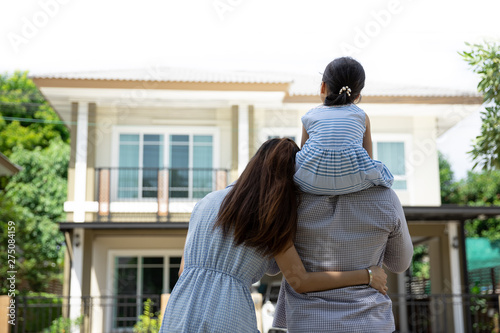 Happy Asian family. Father, mother and daughter near new home. Real estate background with copy space