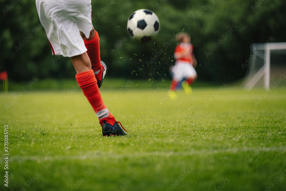 Football Kick. Youth Player Kicking Soccer Ball on Field. Football Ball in Motion. Legs of Sports Soccer Football Player Sportsman In Motion With Ball Football Kick. Youth Player Kicking Soccer Ball on Field. Football Ball in Motion. Legs of Sports Soccer Football Player Sportsman In Motion With Ball