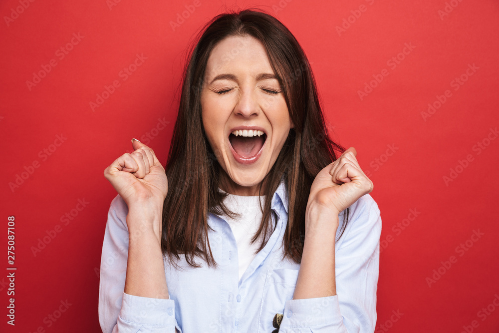 Surprised emotional young beautiful woman posing isolated over red wall background. Surprised emotional young beautiful woman posing isolated over red wall background.