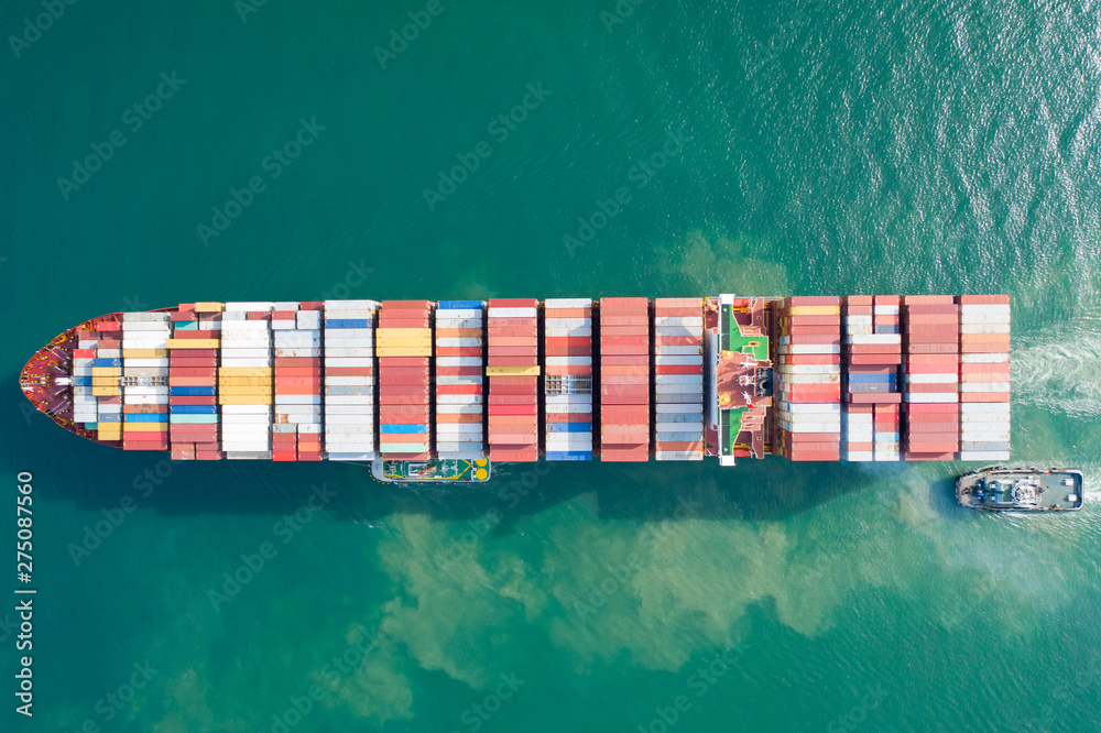 Fototapeta premium Aerial view and top view. Container ship in pier with crane bridge carries out export and import business in the open sea. Logistics and transportation