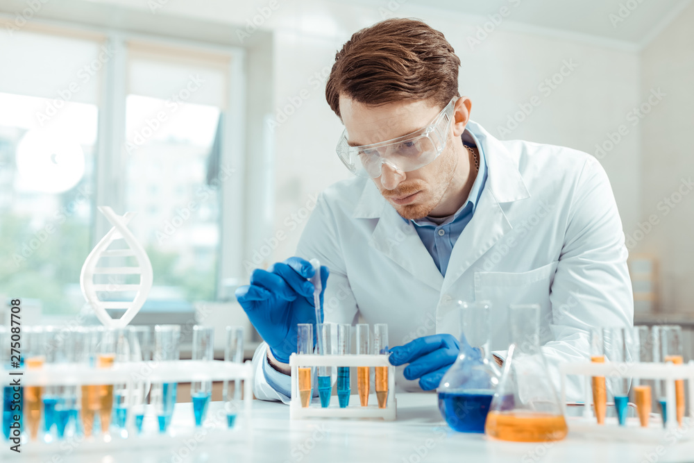 Serious handsome scientist wearing special protective glasses Serious handsome scientist wearing special protective glasses
