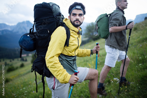 Two man traveling in a mountains staying on footpath relaxing and enjoying the wiew