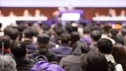 Conference with panel speakers on stage at convention. Presenters at corporate seminar talking to audience.  Business leadership lecture during executive seminar.
