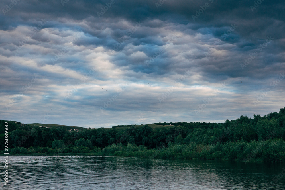 cloudy sky on the river in the summer evening