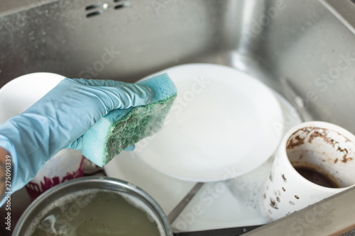 Unwashed dishes and utensils in a kitchen sink. Pile of dirty dishes in a sink. Washing dishes concept.