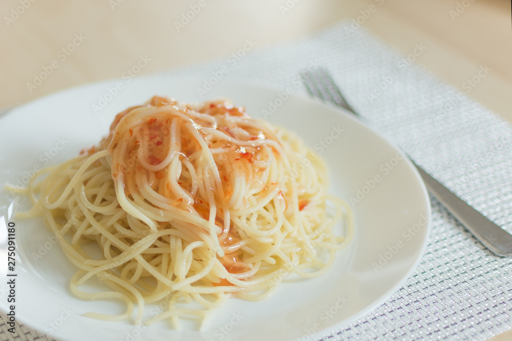 Dish of spaghetti on a plate with sweet savory sauce. Spaghetti serving with sweet chilli sauce. Dish of spaghetti on a plate with sweet savory sauce. Spaghetti serving with sweet chilli sauce.