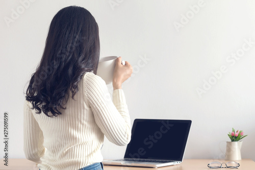 Young happy Asian women working on her laptop at the office.