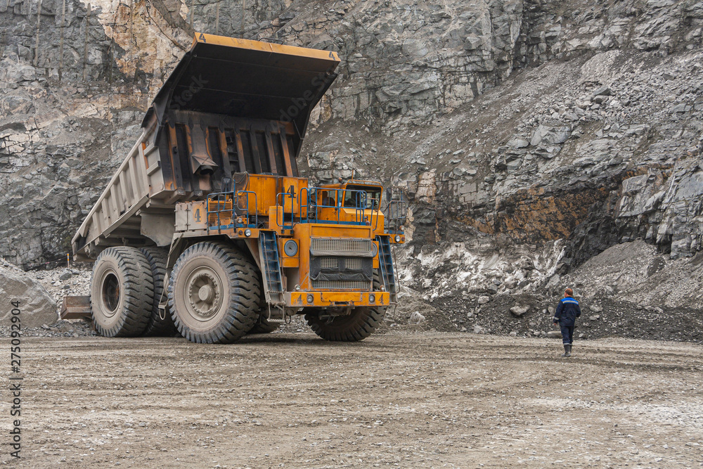 Gigat dump trucks are working in the mine for the production of apatite in the Murmansk region carrying rock.