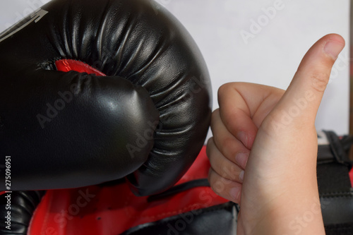 young hand and a black boxing glove