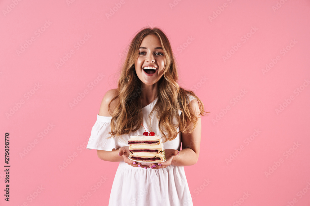Image of happy surprised woman wearing white dress smiling at camera and holding piece of cake Image of happy surprised woman wearing white dress smiling at camera and holding piece of cake