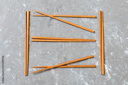 Many bamboo chopsticks on black cement stone background, top view with copy space. a lot of sushi sticks in the form of an ornament © sosiukin