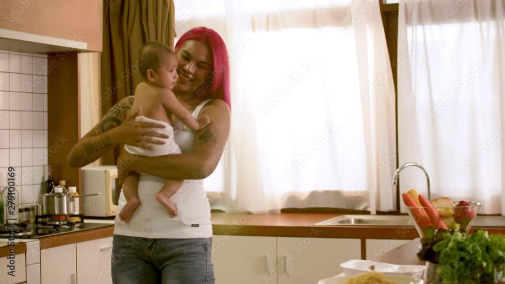 Happy young mother holding newborn baby in kitchen at home Happy young mother holding newborn baby in kitchen at home
