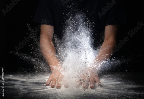hand clap and white flour on black background