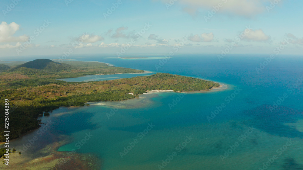 Tropical island Balabac covered with green rain forest against the blue sky with clouds and blue sea from above. Seascape: Ocean and sky. Palawan, Philippines