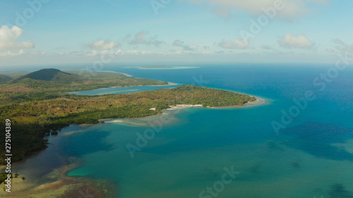 Tropical island Balabac covered with green rain forest against the blue sky with clouds and blue sea from above. Seascape: Ocean and sky. Palawan, Philippines