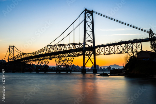 landscape with cable-stayed iron bridge at sunset with seascape with blue and golden sky, Hercilio Luz Bridge Florianopolis - Santa Catarina - Brazil photo
