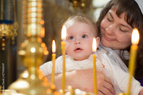 Baptism of the Child. The mother holds the child in the arms near the altar. The baby is in the church.Mother with a baby in church at the altar