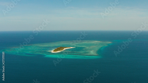 Tropical island on an atoll with beautiful sandy beach by coral reef from above. Canimeran Island and coral reef. Summer and travel vacation concept.