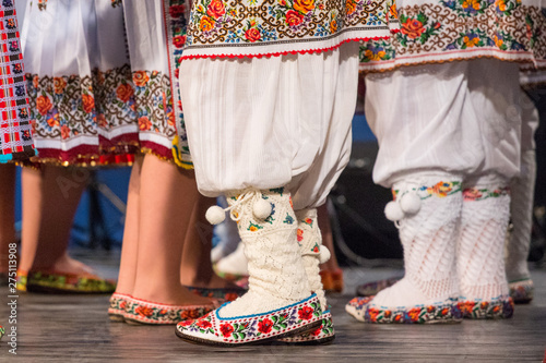 Foto Close up of legs of young Romanian dancers perform a folk dance in traditional folkloric costume