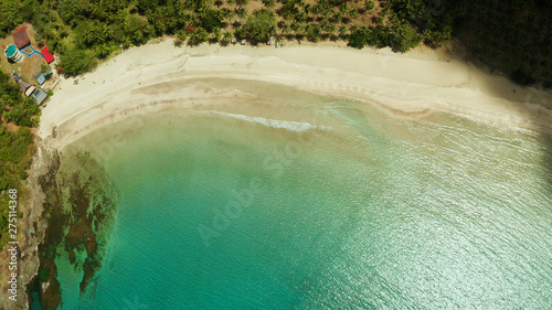 Tropical sandy beach with tourists in blue water, aerial view. Nagtabon. Palawan, Philippines. Seascape with lagoon in sea, sand, palm trees. Summer and travel vacation concept