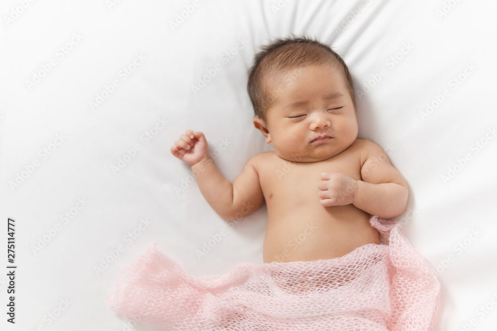 Adorable asian newborn baby in pink wrap sleeping on white blanket background. Adorable asian newborn baby in pink wrap sleeping on white blanket background.