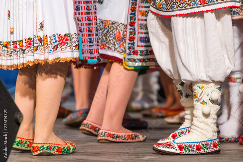 Close up of legs of young Romanian dancers perform a folk dance in traditional folkloric costume. Folklore of Romania