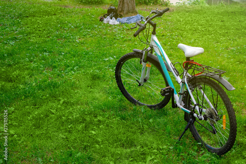 Female bike on the grass in the forest. Picnic in nature. Cycling in the forest or park.