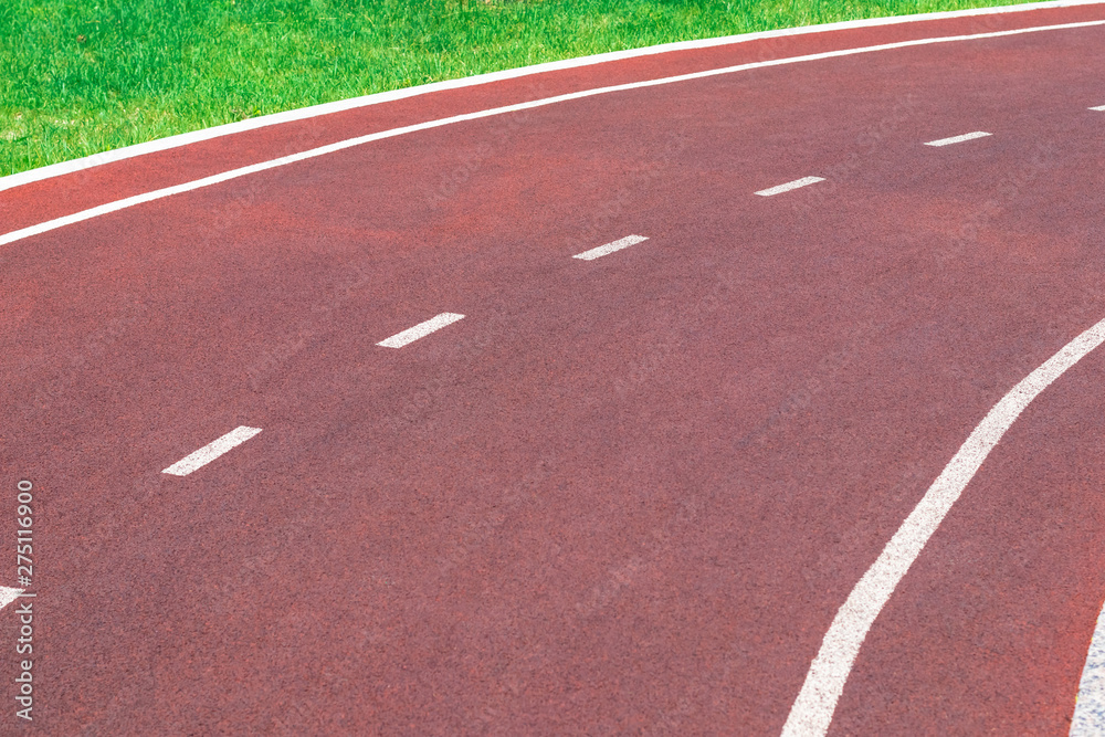 Red synthetic treadmill or bike lane with white markings, turns right. Red synthetic treadmill or bike lane with white markings, turns right.