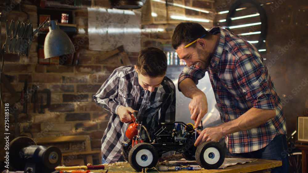 Father and son are working on a radio control toy car in a garage at home.  Stock Photo | Adobe Stock