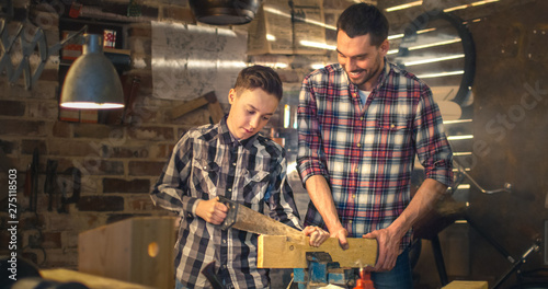 Father and son are woodworking in a garage at home.
