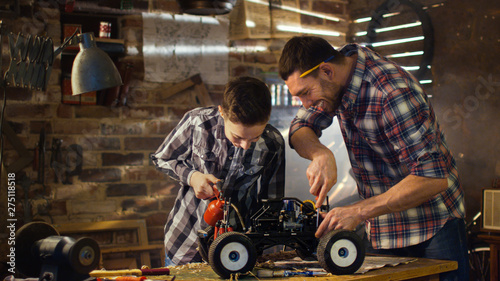 Cuadro en lienzo Father and son are working on a radio control toy car in a garage at home