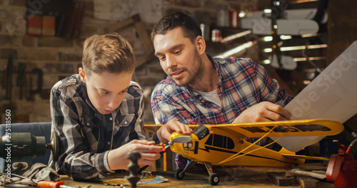 Foto Father and son are modeling a toy airplane in a garage at home.